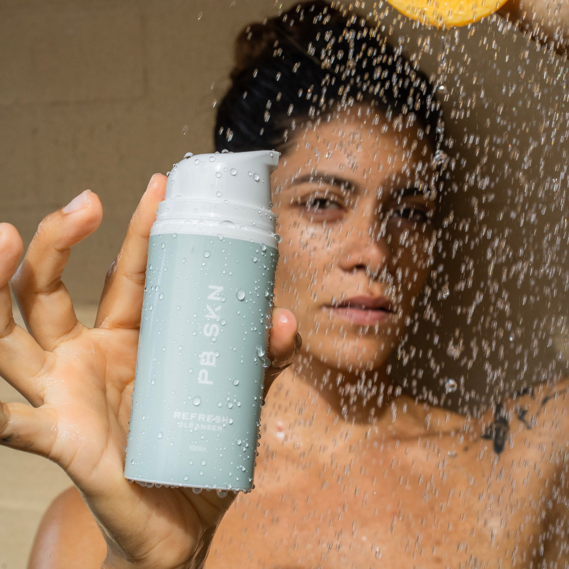 Woman using PB SKN post-workout gel cleanser in shower after exercise
